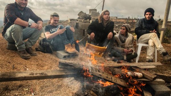 Israeli settlers gather around a fire in the settlement outpost of Amona. (AFP/File)