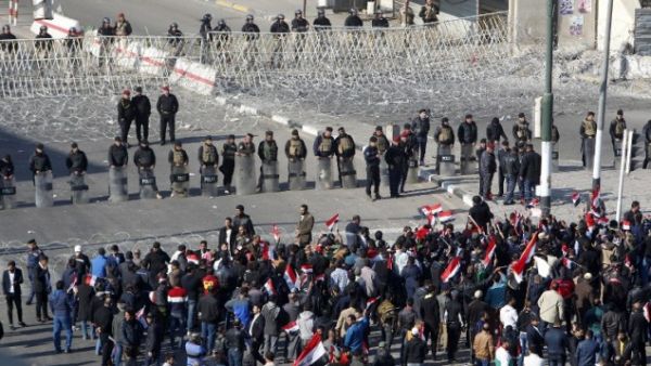 Iraqi security forces stand guard as supporters of the Sadrist movement gather during a demonstration in Baghdad. (AFP/File)