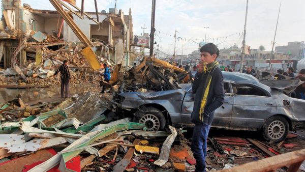 A boy in Baghdad inspects a car bombing in December. At least 17,000 Iraqi civilians were killed last year. (AFP/Ahmad Al-Rubaye)