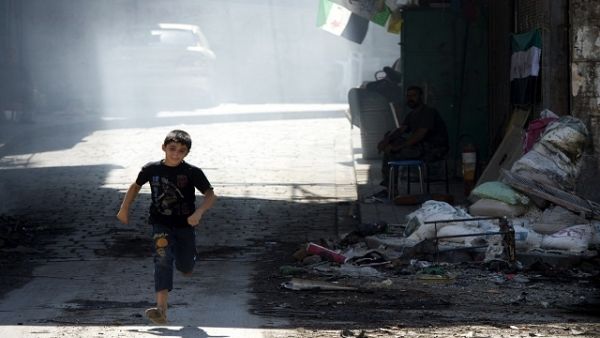 A Syrian boy runs to cross a street where snipers take positions in the old city of Aleppo. (AFP/File)