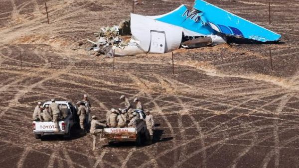 Egyptian Military members approach a plane's tail at the wreckage of a passenger jet bound for St. Petersburg in Russia that crashed in Hassana, Egypt, on Sunday. (YouTube)