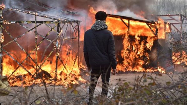 A refugee looks at shacks burning during the dismantling of the "Jungle" migrant camp in Calais, on February 29, 2016. (AFP/Philippe Huguen) 