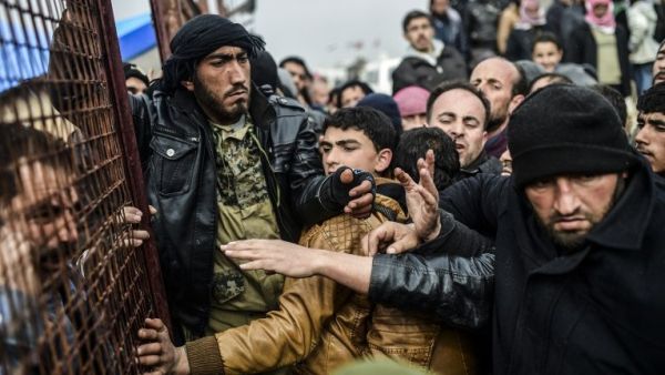 Refugees push each other as they wait for tents as Syrians fleeing the northern embattled city. (AFP/File)