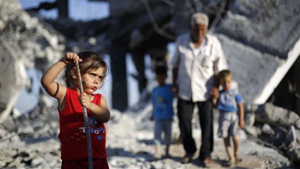 A Palestinian girl plays in the rubble of buildings destroyed during the 50-day 2014 Israeli war in Gaza City, July 21, 2015. (AFP/File)