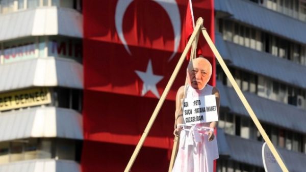 A picture of US-based preacher Fethullah Gulen placed on a hanging dummy in front of a Turkish national flag at Kizilay Square in Ankara on August 2, 2016, during a protest against July's failed military coup. (AFP/Adem Altan)