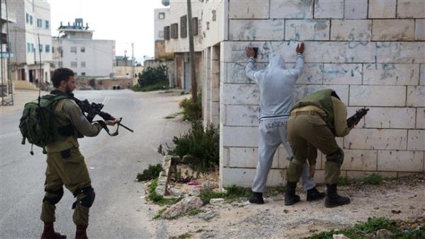 Occupation forces inspect a young Palestinian. (AFP/File)