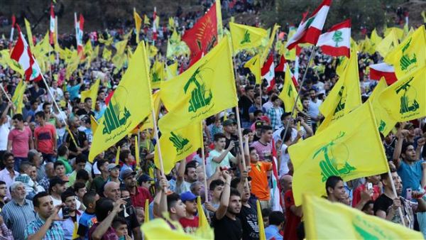 Lebanese people wave flags of Hezbollah in a ceremony on August 14, 2015. (AFP/File)