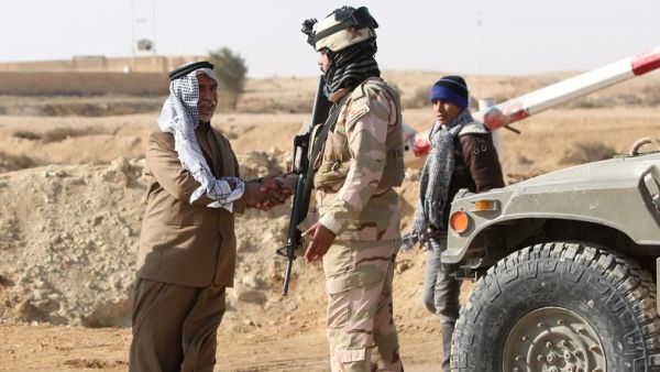 A Sunni Muslim Iraqi man shakes the hand of a soldier at Ein Tamer as families flee their homes in the city of Fallujah. (AFP/File)