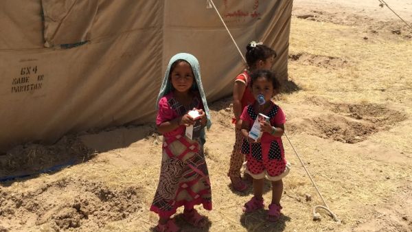 Displaced Iraqi children stand outside a tent at a newly-opened camp. (AFP/File)