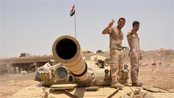 Iraqi government forces flash the sign of victory on their tank on June 22, 2016, some 40 kilometers (25 miles) west of Qayyarah, during their operation to take the city and make it a launch pad for an assault on Mosul. (AFP/File)
