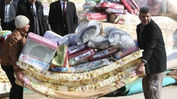 Iraqis who fled Fallujah with their families carry blankets and mattresses distributed by the International Organization for Migration (IOM). (AFP/File) 