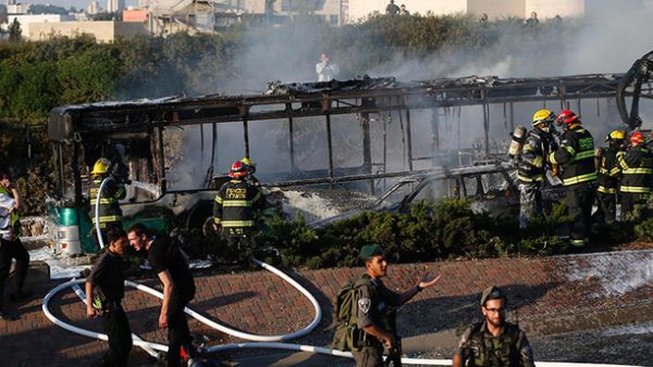 Israeli security forces stand guard as firemen extinguish a burning bus following an attack in Jerusalem on April 18, 2016. (AFP/File)