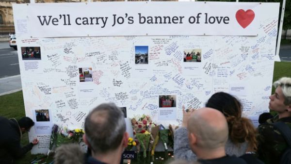 People stand in front of a large board in Parliament Square, central London, bearing messages in remembrance of murdered Labour MP Jo Cox. (AFP/File)
