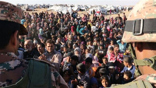 The photo shows Syrian refugees, stuck on the Jordanian- Syrian border, waiting to cross into Jordan, at the Hadalat border crossing on January 14, 2016. (AFP/File)