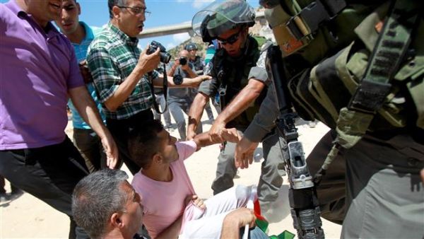Israeli forces scuffle with Palestinian protesters during clashes following a demonstration against land confiscation for Israel's apartheid barrier in the West Bank. (AFP/File)