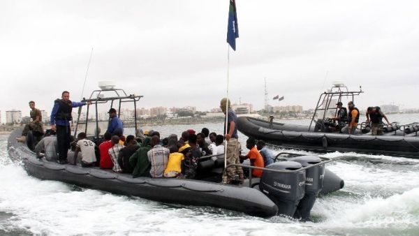 Migrants sit on a boat of Libyan coastguard taking them ashore after they were rescued off the town of Qarabulli. (AFP/File)