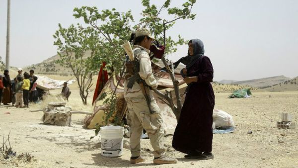 A Syrian woman who fled the assault launched by Arab and Kurdish forces against Islamic State (IS) fighters in the town of Manbij talks to a Kurdish fighter upon her arrival at an encampment on the outskirts of the town, June 4, 2016. (AFP/Delil Souleiman)