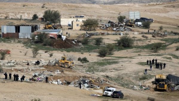 Israeli policemen stand guard as bulldozers demolish homes in Bedouin villages. (AFP/File)