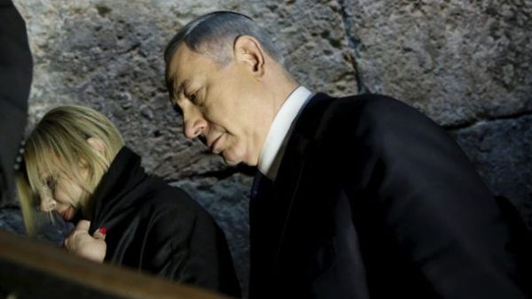Benjamin and Sara Netanyahu leave after praying at the Westen Wall Tunnel in Jerusalem. (AFP/File)