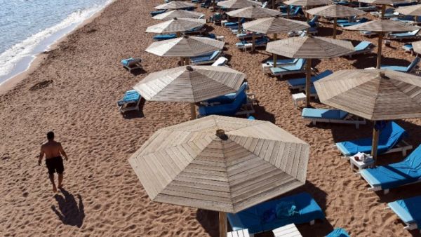 A tourist walks past empty sunbeds on a beach in Egypt. (AFP/File)