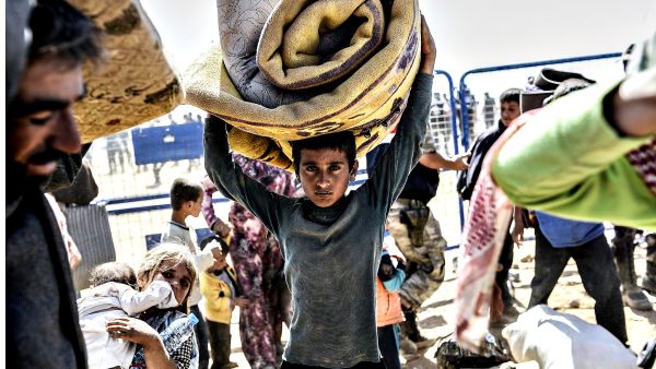 A young boy carries his bed cover. (AFP/Bulent Kilic) A young boy carries his bed cover. (AFP/Bulent Kilic)