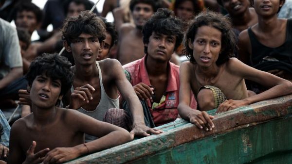 Rohingya migrants sit on a boat drifting in Thai waters off the southern island of Koh Lipe in the Andaman sea on May 14, 2015. The boat was found drifting in Thai waters on May 14, according to an AFP reporter at the scene, with passengers saying several people had died over the last few days. (AFP/Christophe Archambault) 