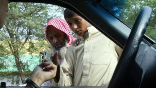 A driver hands money to beggars in Riyadh. (AFP/File)
