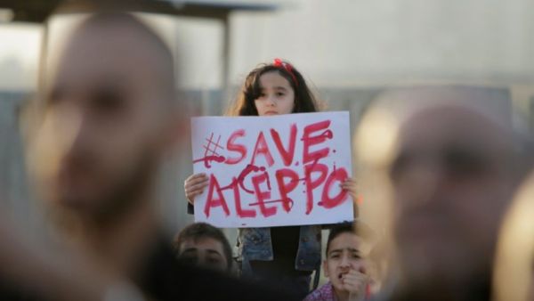 A Syrian girl holds a placard during a rally in solidarity with Aleppo, in the Lebanese northern port city of Tripoli, on May 1, 2016. (AFP/Ibrahim Chalhoub)
