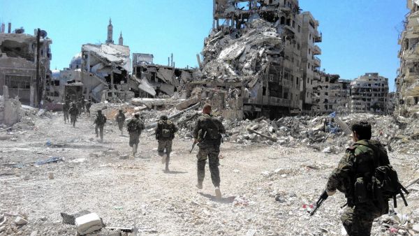 Syrian regime forces patrolling a city devastated by conflict. (AFP/File)