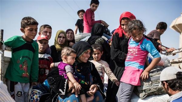 This file photo shows Syrian refugees, who had fled Tal Abyad, re-entering Syria with their belongings from Turkey, June 22, 2015. (AFP/File)