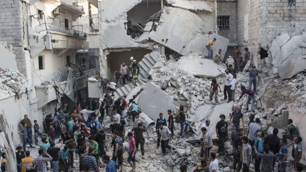 People gather around the destruction left after air strikes in Syria. (Twitter)