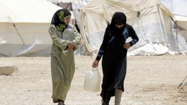 Syrian refugees carry water containers as they walk through the northern Jordanian Zaatari refugee camp on May 18, 2013. (AFP/Khalil Mazraawi)