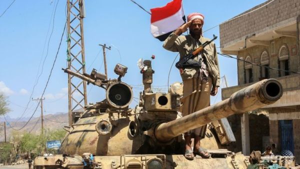 A Yemeni fighter loyal to the country's exiled president salutes on top of a tank at a checkpoint in Taez on Apr 11, 2016. (AFP/Ahmad Al-Basha)