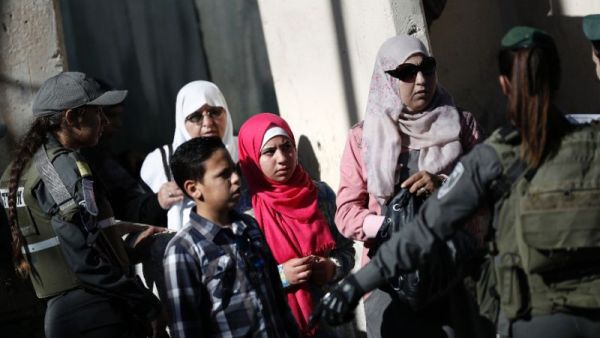 A Palestinian family at an Israeli checkpoint between the West Bank town of Bethlehem and Jerusalem. (AFP Photo/Thomas Coex)
