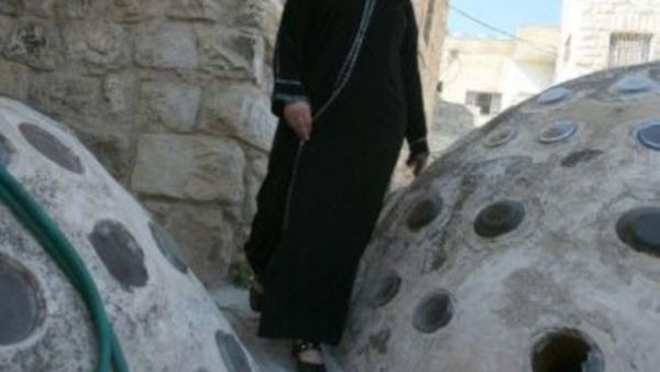 الفلسطينية زهيرة قفيشة تتنقل على اسطح بيوت شارع الشهداء في الخليل بعد ان باتت المنفذ الوحيد الى منزلها