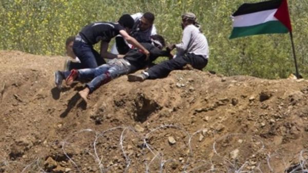 متظاهرون فلسطينييون ينقذون شابا أصيب بالرصاص الإسرائيلي على حدود الجولان 