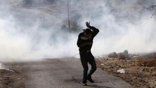 فلسطيني يفر هربا من عبوة غاز مسيل للدموع اطلقها الجيش الاسرائيلي قرب رام الله 
