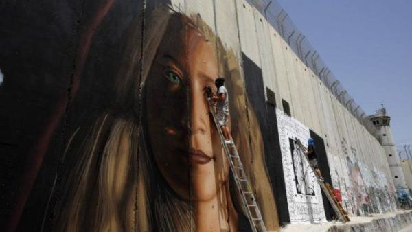 صورة عهد التميمي على جدار الفصل العنصري في الضفة الغربية