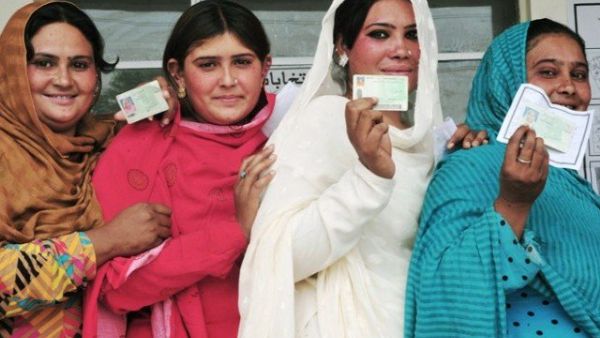 Pakistani voters pose with their national identity cards as they queue to cast their ballots at a polling station during the general election in Rawalpindi. (AFP/ File)