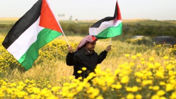 فلسطيني يحمل العلم الوطني في بيت حنينا خلال احياء يوم الارض/أ.ف.ب