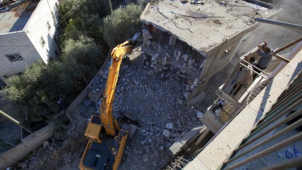 فلسطيني ينظر على جرافات الاحتلال وهي تدمر منزله في قرية صور بار في القدس الشرقية/أ.ف.ب