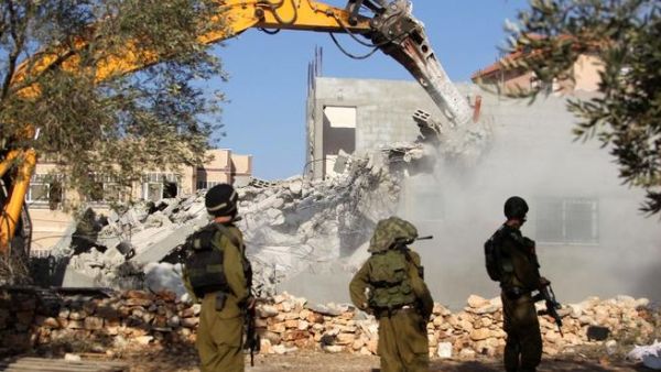 جنود اسرائيليون يحرسون جرافة تقوم بهدم منزل فلسطيني في قرية حارس بالقرب من مدينة نابلس/أ.ف.ب