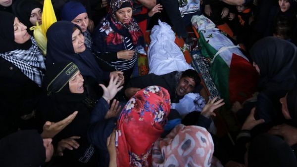 Palestinians mourn over the bodies of Maram Abu Ismail, 23, and her brother Ibrahim Taha, 16, who were shot dead by Israeli police last month at the Qalandiya checkpoint, during their funeral in the West Bank village of Qatanna, on May 23, 2016. (AFP/Abbas Momani)