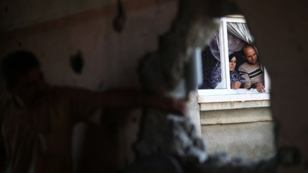 Palestinians check the damage in their house after it was hit by Israeli tank fire on September 6, 2016 in Beit Hanoun in the northern Gaza Strip. (AFP/Mohammed Abed)