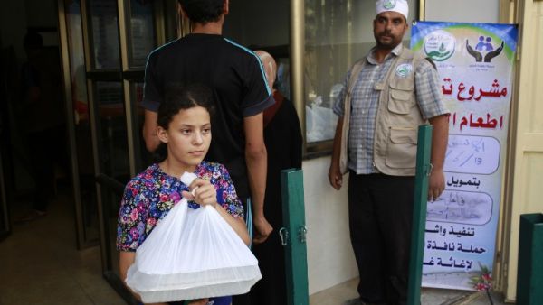 A Palestinian girl receives food from the tekiyya, Arabic name for the soup kitchen, during the holy Muslim month of Ramadan in Gaza City on June 13, 2016. (AFP/Mohammed Abed)