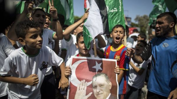 Palestinian supporters of the Hamas movement hold portraits of Turkish President Recep Tayyip Erdogan as they shout slogans against the military coup. (AFP/File) 