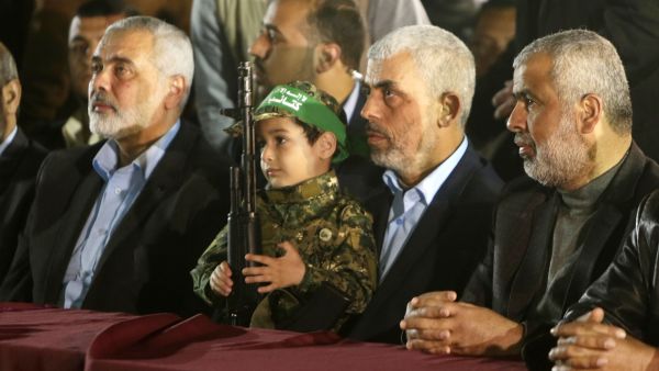 Hamas' leader, Yahya Sinwar, sits second from right at a memorial for assassinated Hamas leader Mazen Fuqaha. (AFP/Mahmud Hams)