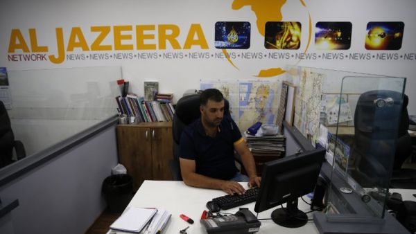 Employees of Qatar based news network and TV channel Al-Jazeera are seen at their Jerusalem office on July 31, 2017 (AFP)