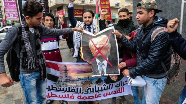 Palestinian protesters prepare to burn a picture of US President Donald Trump in the southern Gaza Strip town of Rafah on December 6, 2017. (Said Khatib/AFP)