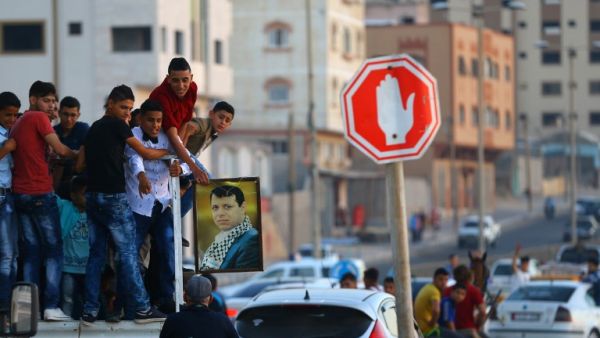 Palestinian youths hold a framed portrait of Mohammed Dahlan, an exiled senior Fatah official and rival to Mahmoud Abbas who was sentenced in absentia to three years in prison on corruption charges, during a wedding in Gaza City, on June 29, 2017. (Mohammed Abed/AFP)